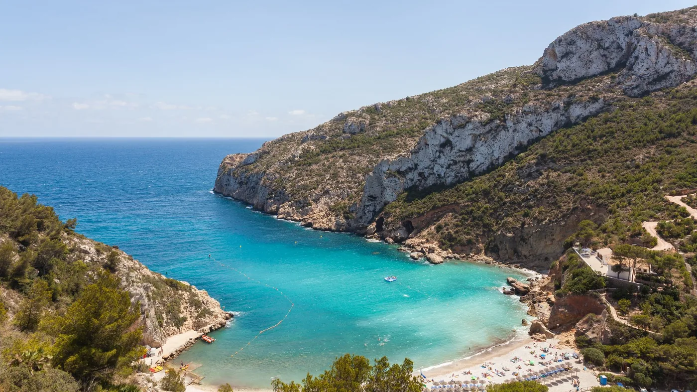 Palmstrandad kust vid Calpe med Peñón de Ifach i bakgrunden — foto: ToniDlaCala